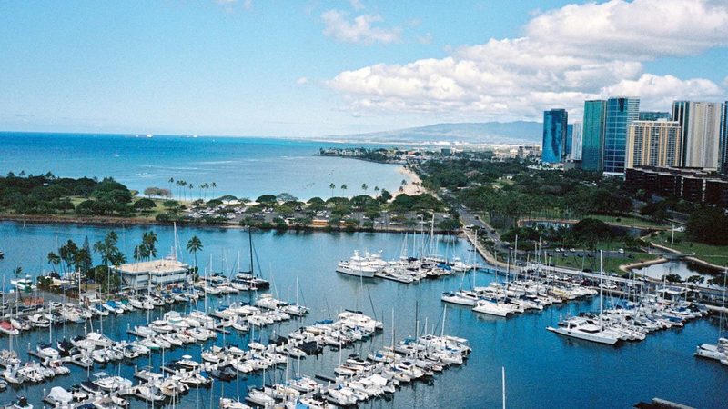Aerial view of Ala Wai Boat Harbor full of powerboats and sailboats with the Honolulu skyline, Oahu, Hawaii