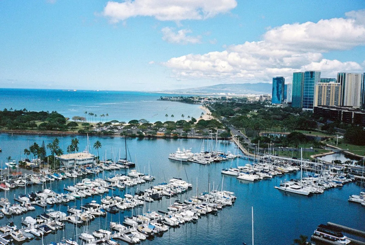 Aerial view of Ala Wai Boat Harbor packed with powerboats and sailboats, with Magic Island and the Honolulu skyline behind, Oahu, Hawaii