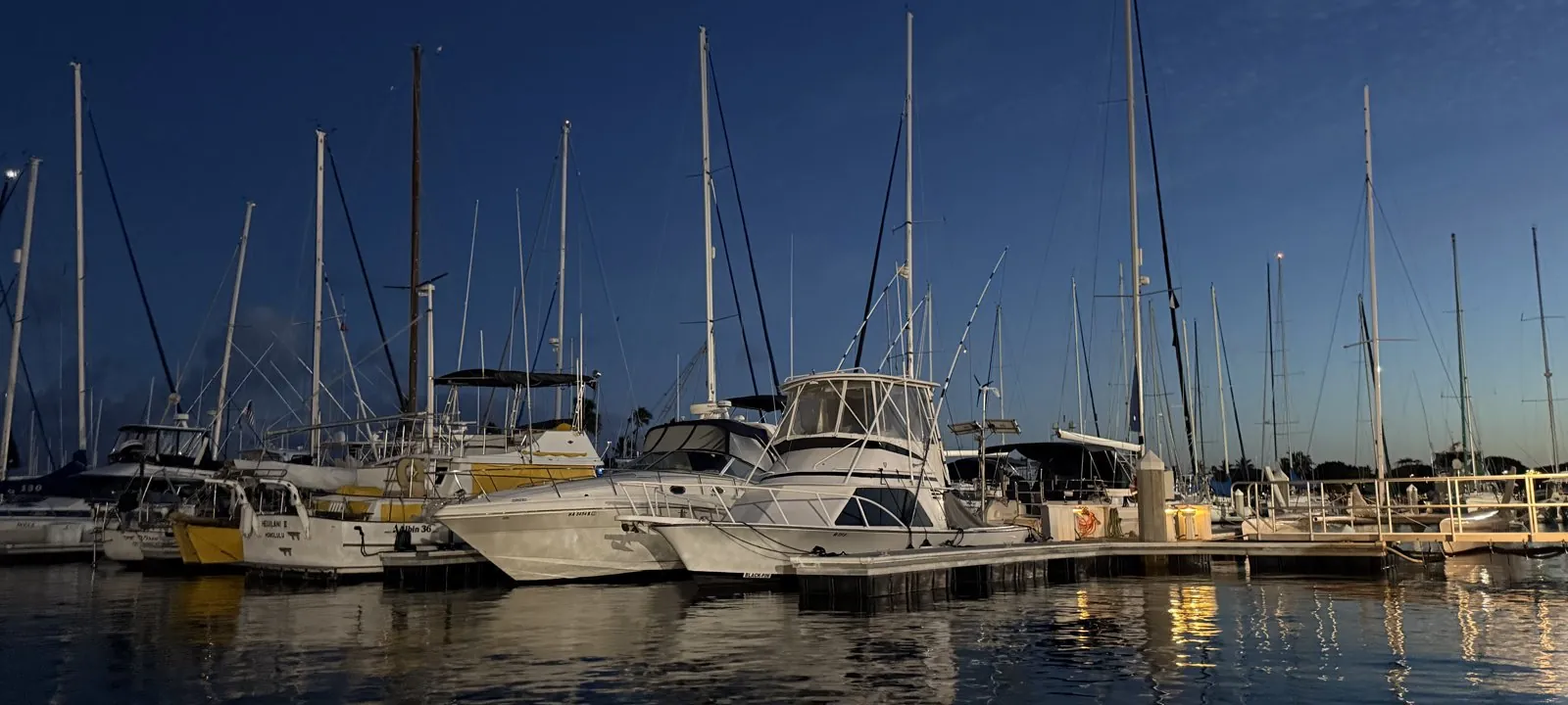 Powerboat and sailboats moored at dusk in a Honolulu marina, Oahu, Hawaii