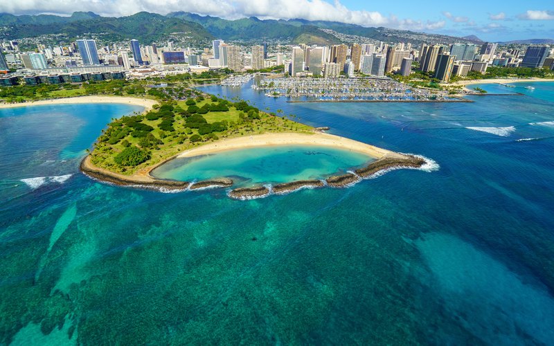Aerial view of the Ala Wai Boat Harbor full of boats with Magic Island and the Honolulu skyline on Oahu